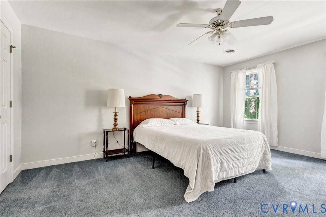 Wall-to-wall carpeting and a ceiling fan with integrated lighting