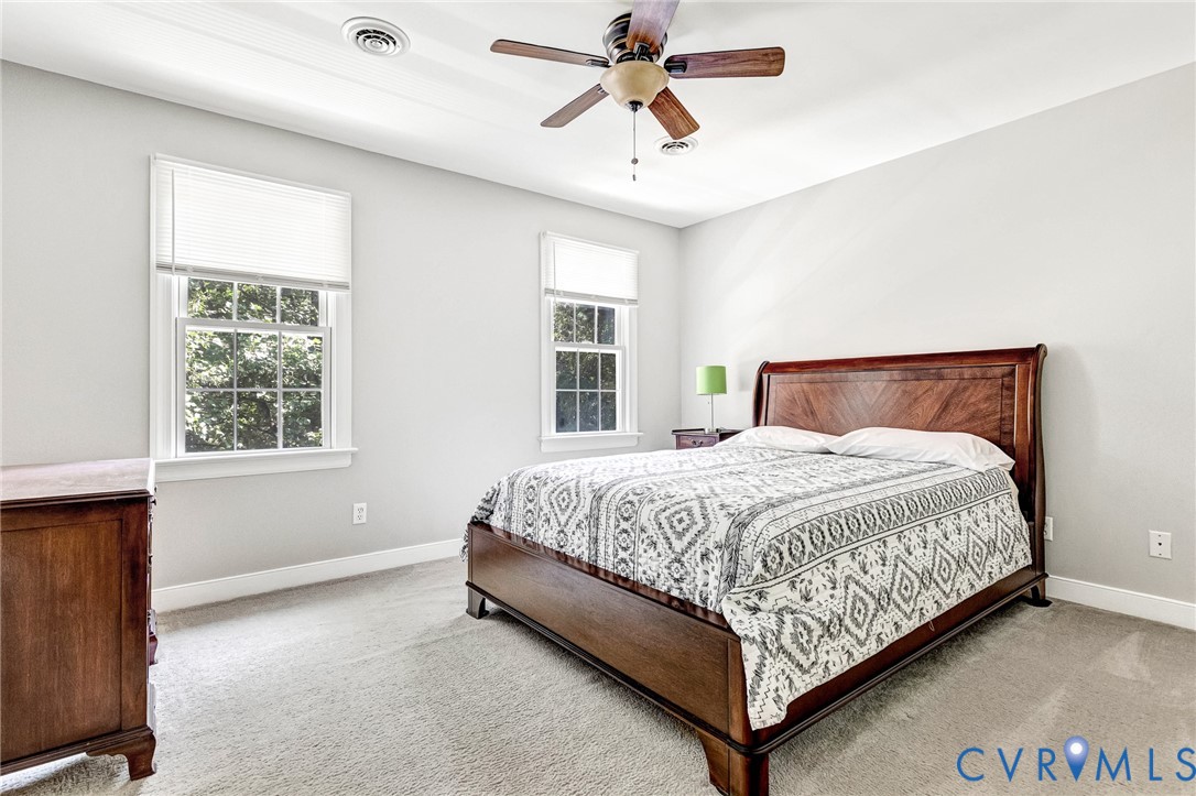 Light-toned walls, two double-hung windows, and a ceiling fan with integrated lighting