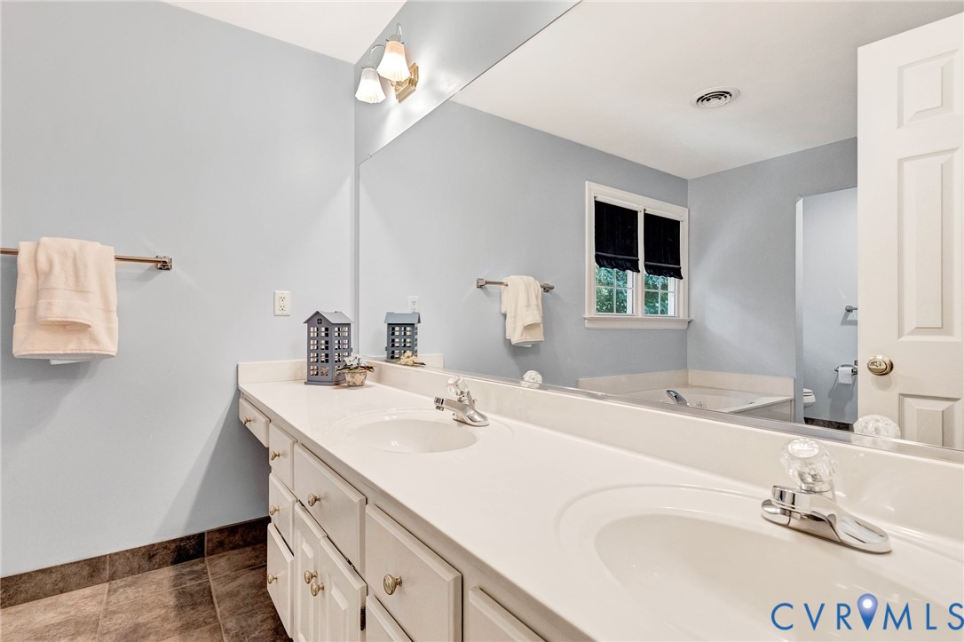 Dual vanity with white cabinetry, integrated sinks, white countertops, and chrome fixtures