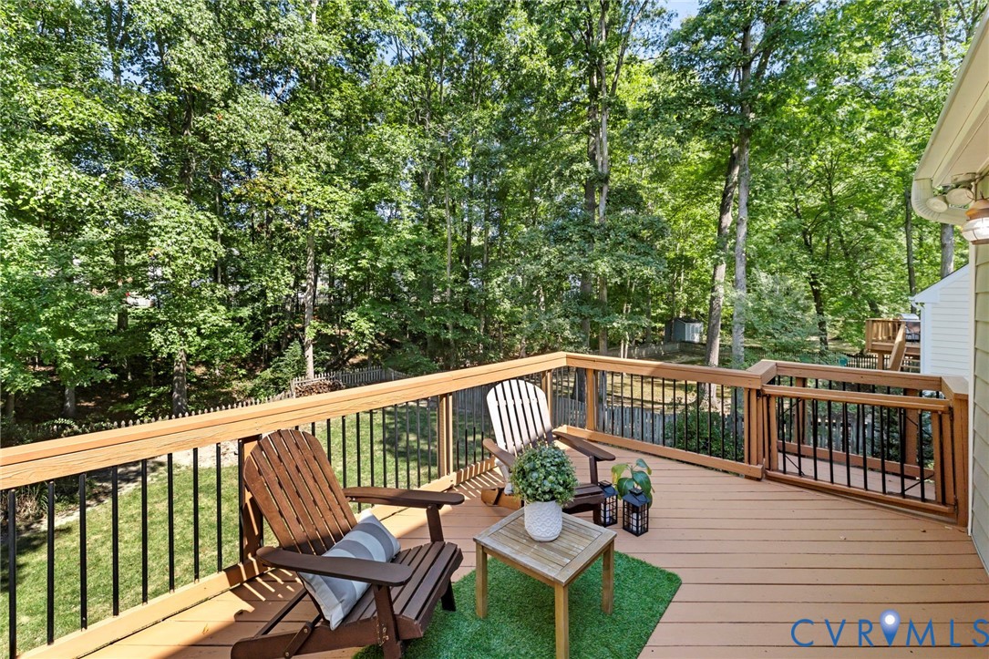 Spacious wood-tone deck with black metal balusters and wood railings