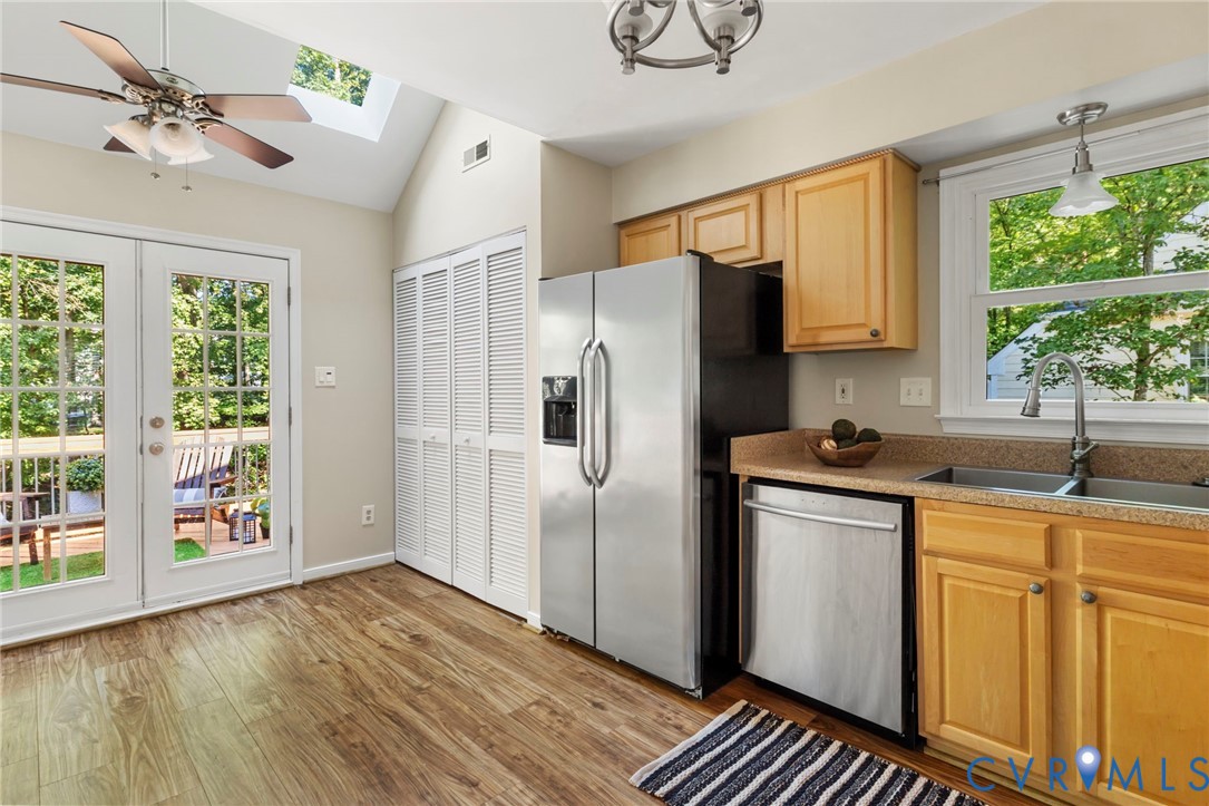 Wood-finish flooring with vaulted ceilings, skylight, and recessed lighting