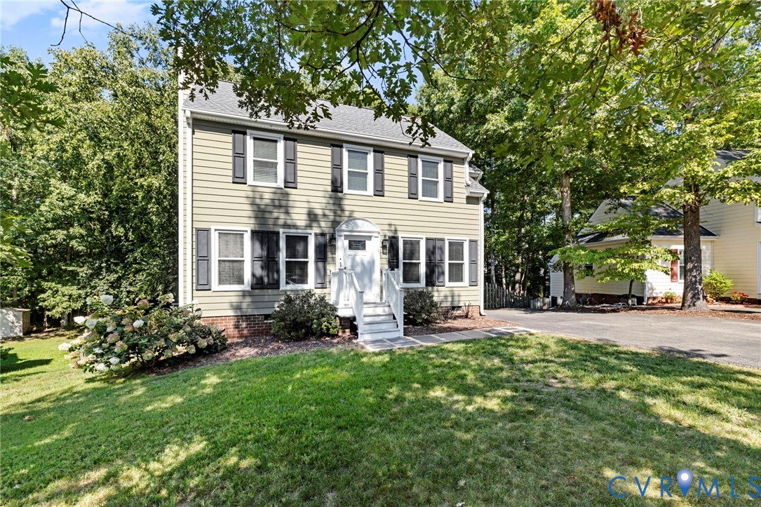 Two-story residence featuring siding exterior, white trim, and dark shutters