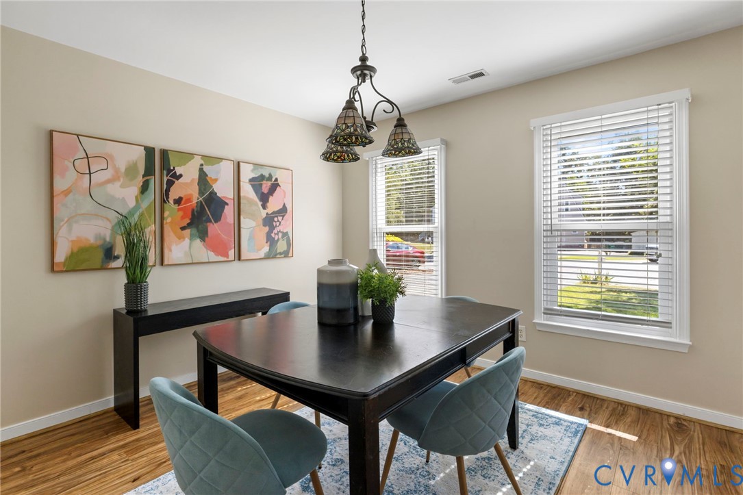 Wood-finish flooring, neutral wall tones, and two windows with blinds