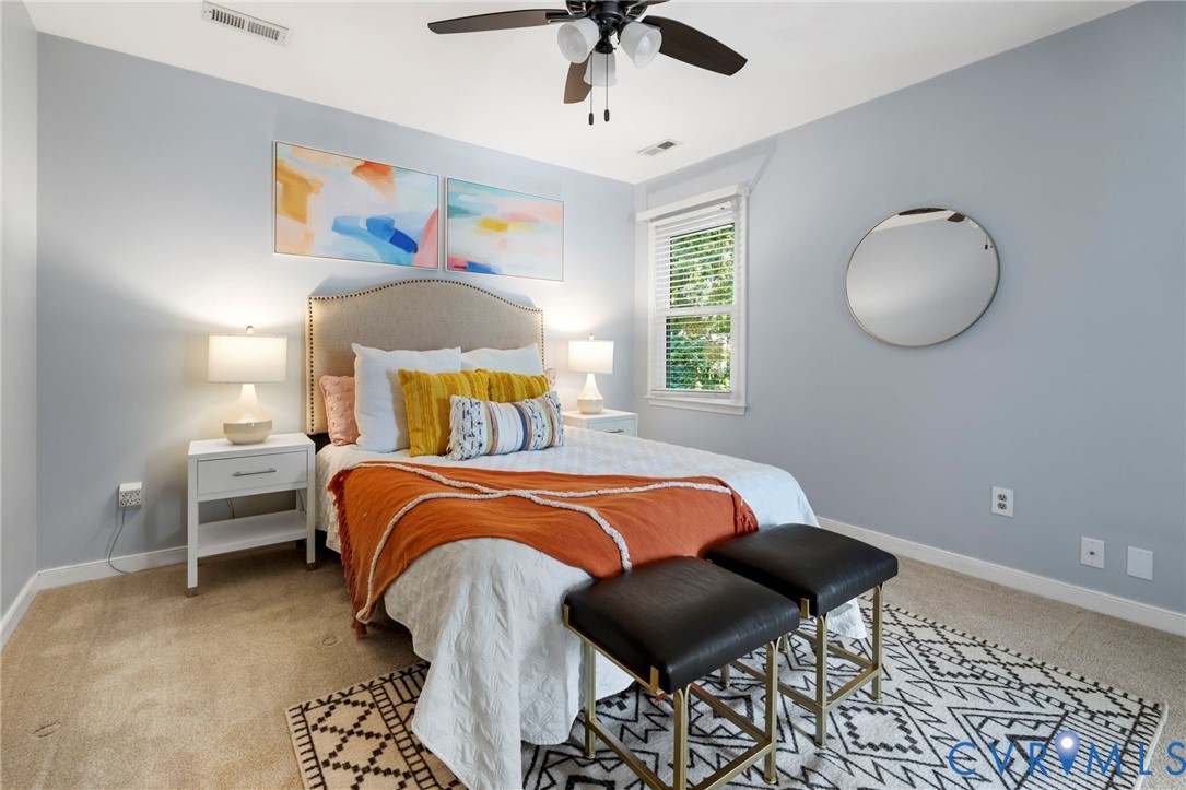 Wall-to-wall carpeting and a ceiling fan with integrated lighting