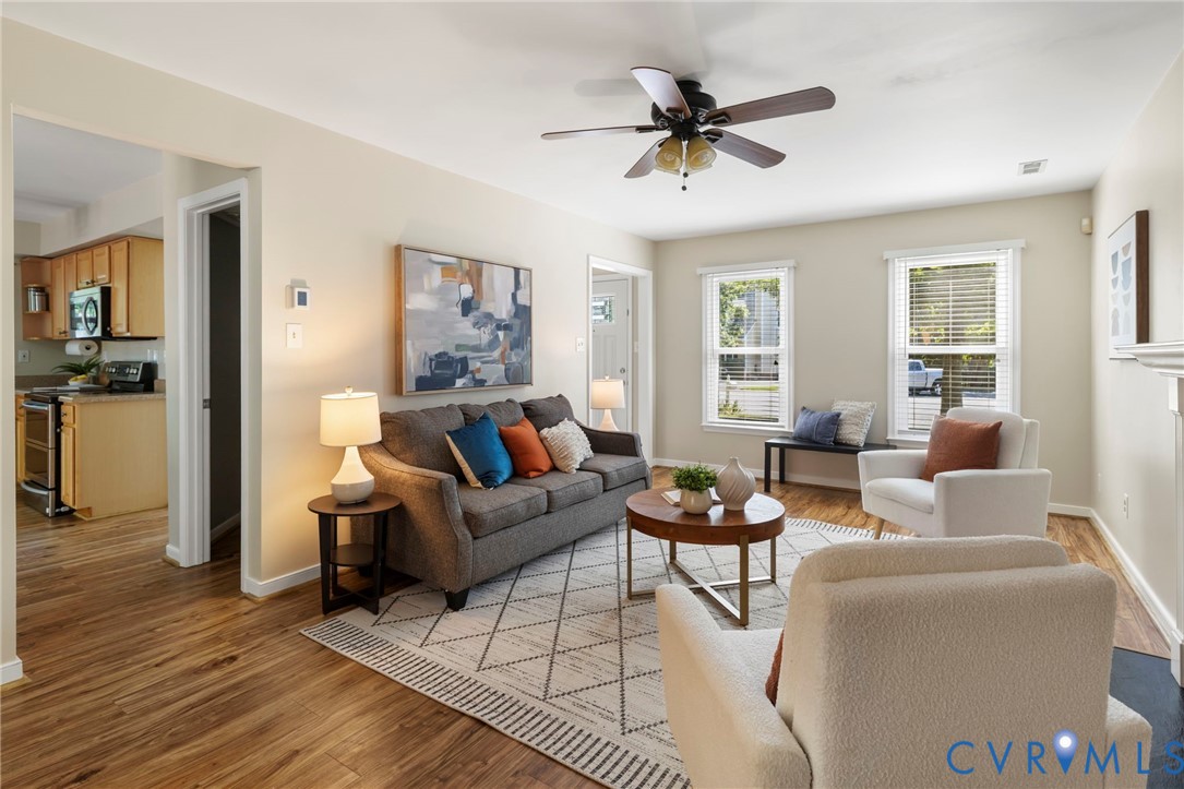 Wood-finish flooring throughout, light-toned wall paint, ceiling fan, and multiple windows with blinds Wood-finish flooring throughout, light-toned wall paint, ceiling fan, and multiple windows with blinds