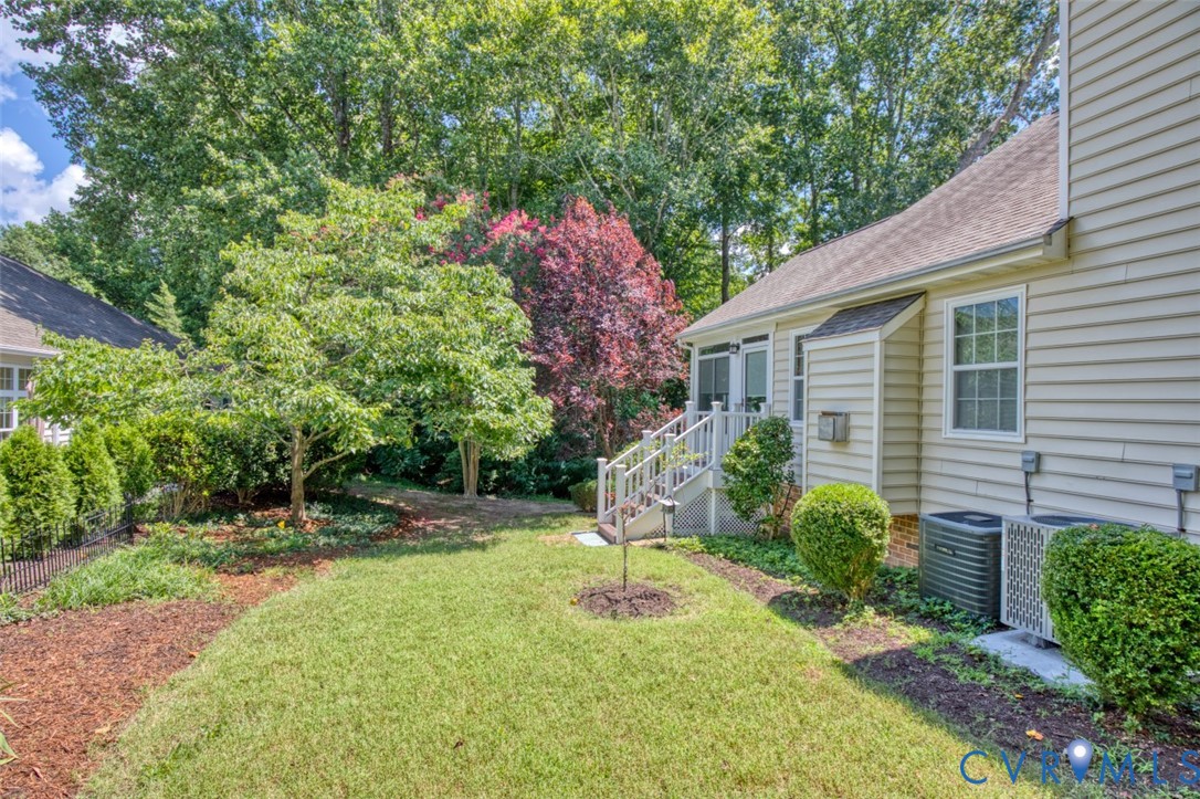 Manicured grounds featuring a lush lawn, mature landscaping with flowering trees, and thoughtfully designed planting beds with mulch borders
