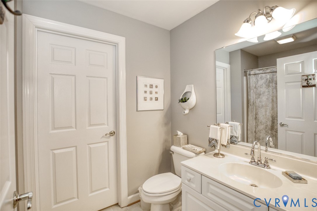 Vanity with an integrated sink, a large wall-mounted mirror, and a three-light fixture