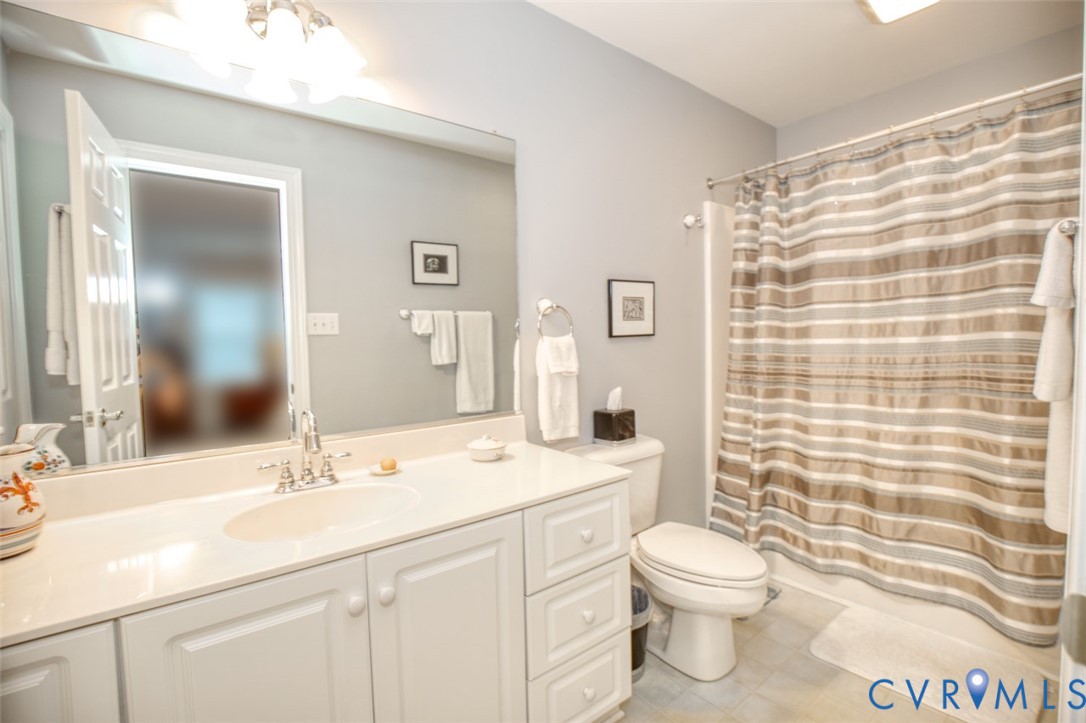 Spa-inspired bathroom featuring a generous vanity with dual sink basins, abundant storage cabinetry, and quartz countertop