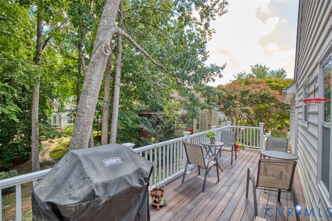 Composite deck with composite decking and white aluminum railings overlooking mature landscaping