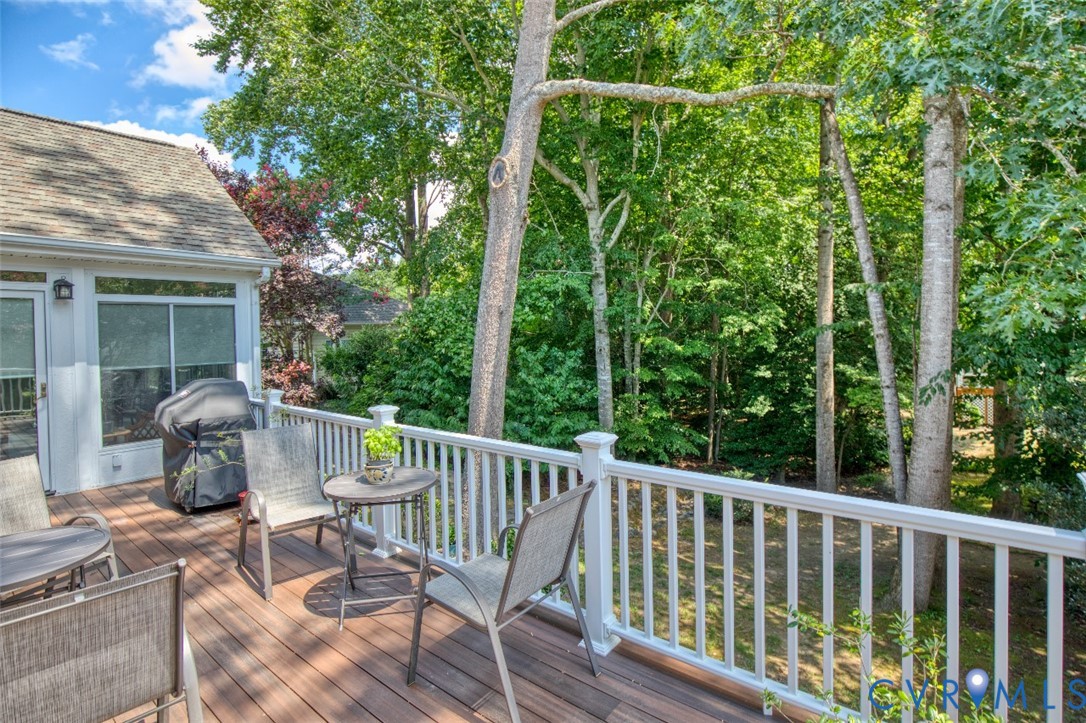 Wood-finish decking with white railing overlooking mature trees