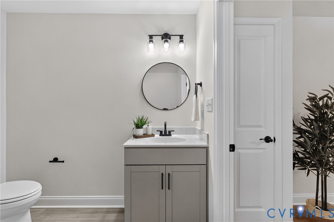 Modern vanity with a gray finish, white countertop, and matte black faucet