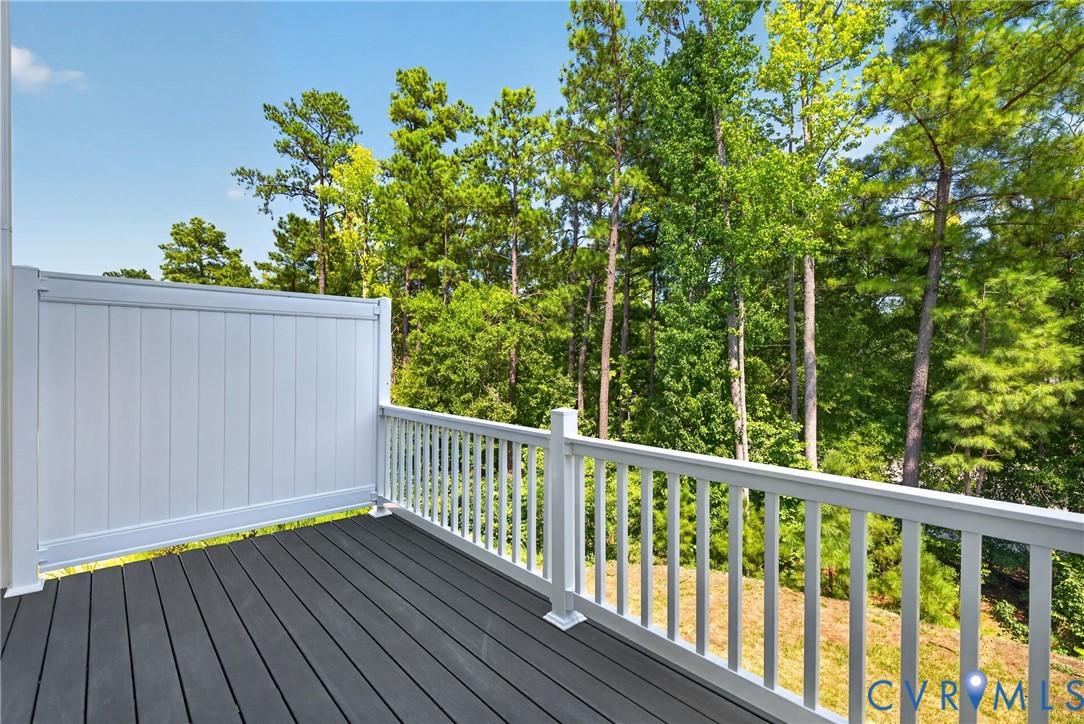 Deck with composite decking, white privacy wall, and white railings
