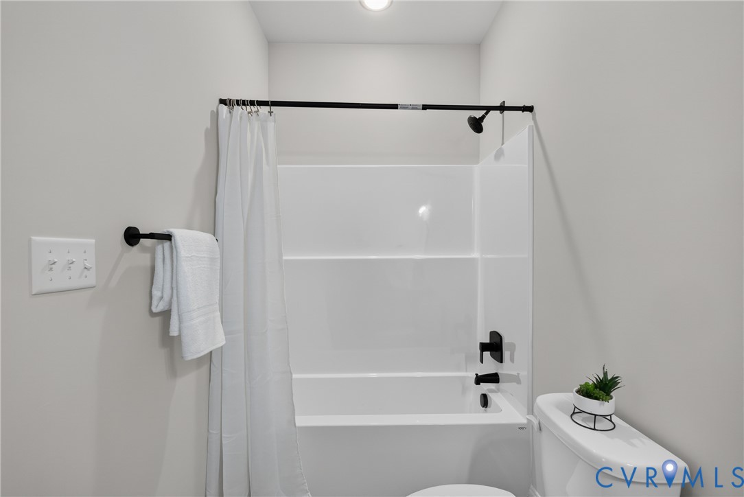 White acrylic tub and shower combination with matte black fixtures