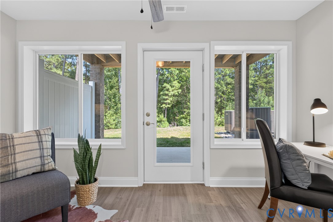 Wood-finish flooring, white trim, and a glass-paneled door