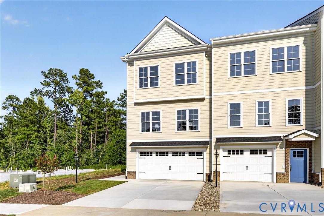 Contemporary townhome with light-colored siding and white window frames