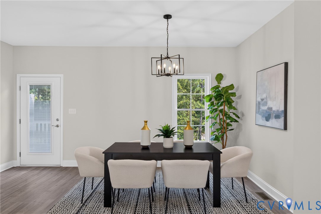 Recessed lighting, wood-finish flooring, and a white paneled door with glass insert