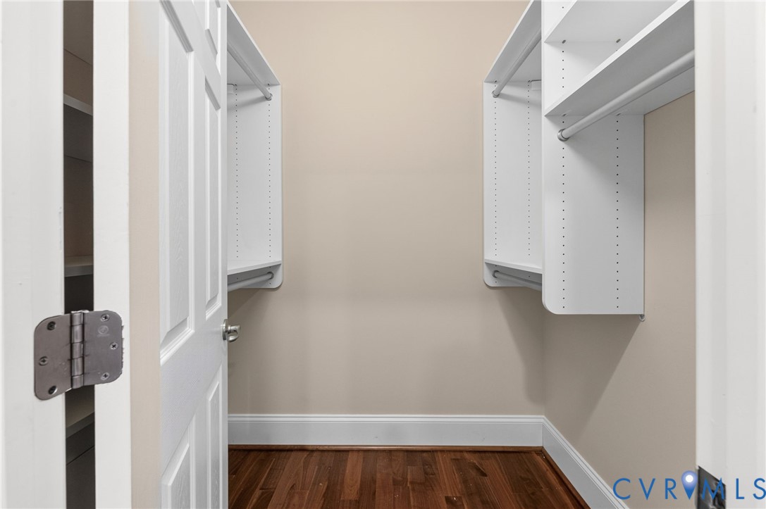 Hardwood flooring, crisp white trim, and adjustable shelving with hanging rods