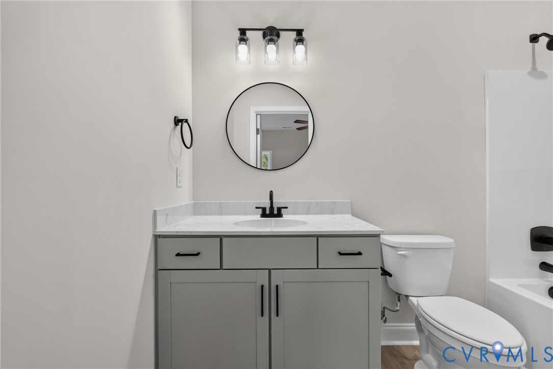 Vanity with gray cabinetry, white countertop, and integrated sink