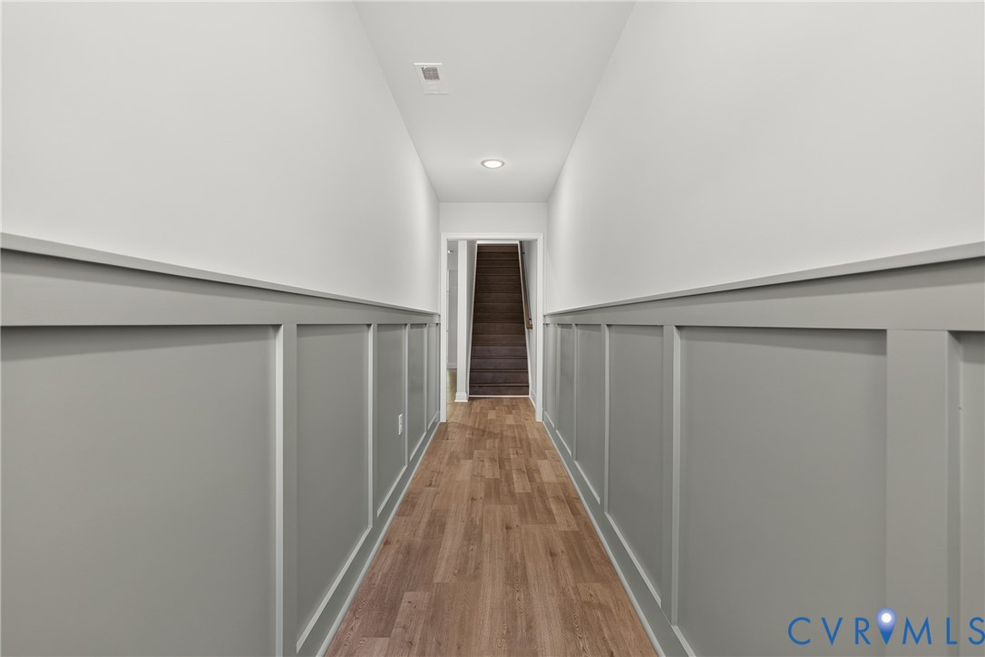 Board and batten wainscoting, wood-finish flooring, recessed ceiling lighting, and a neutral color palette Board and batten wainscoting, wood-finish flooring, recessed ceiling lighting, and a neutral color palette