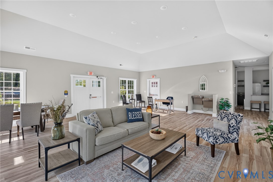 Vaulted ceiling, recessed lighting, wood-finish flooring, multiple windows, double-pane doors