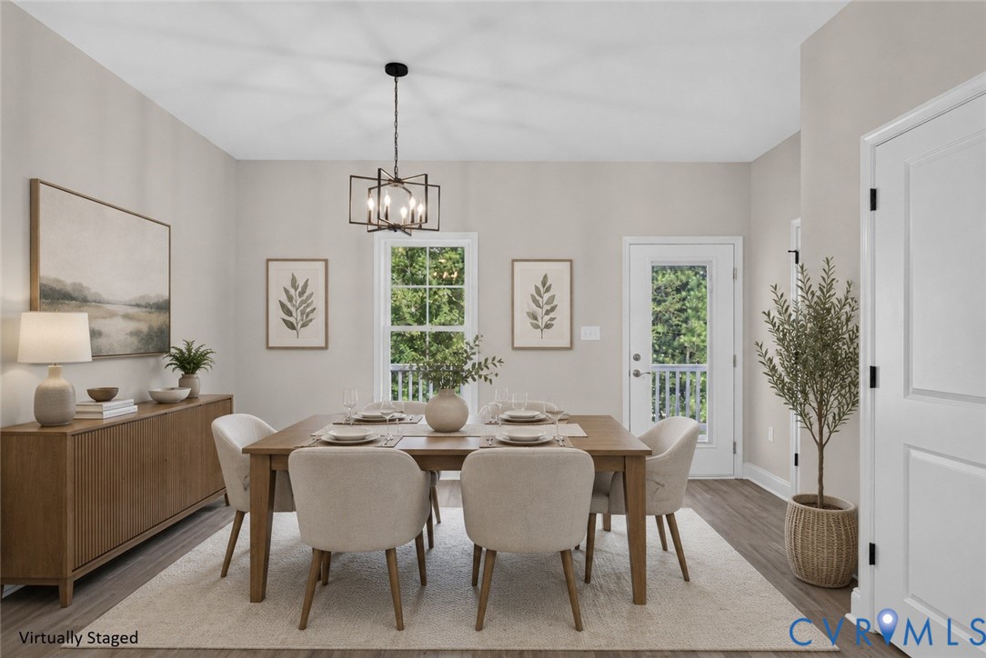 Spacious dining area featuring wood-finish flooring, a contemporary chandelier, and a glass-paned exterior door