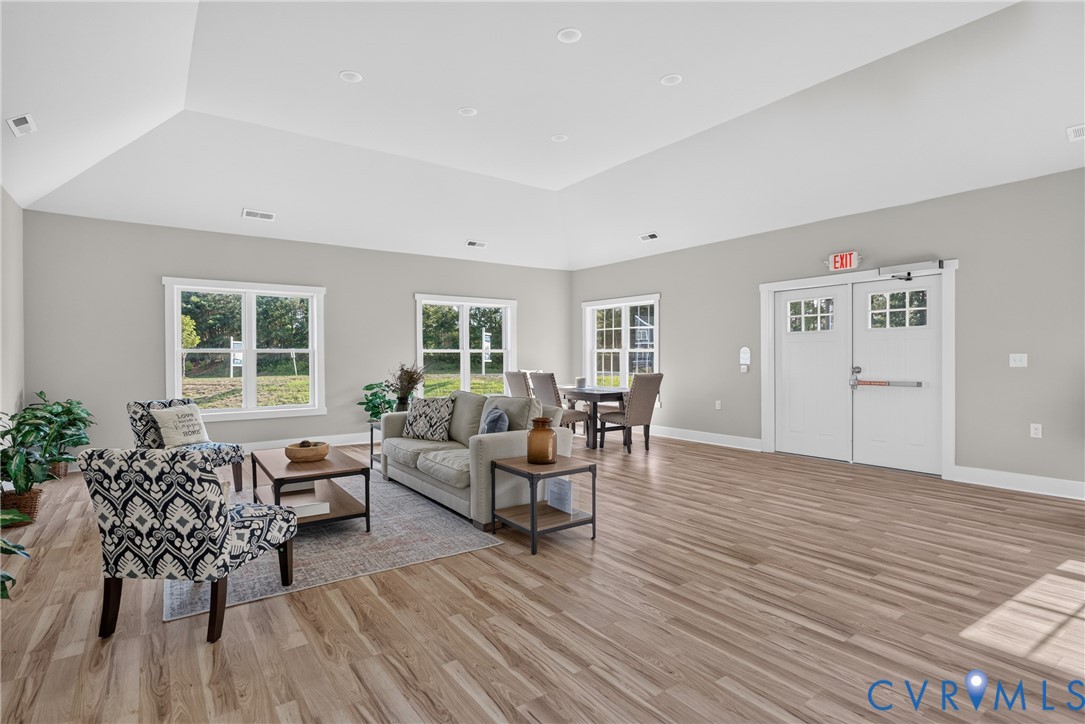 Expansive common area featuring wood-finish flooring, recessed lighting, and a vaulted ceiling
