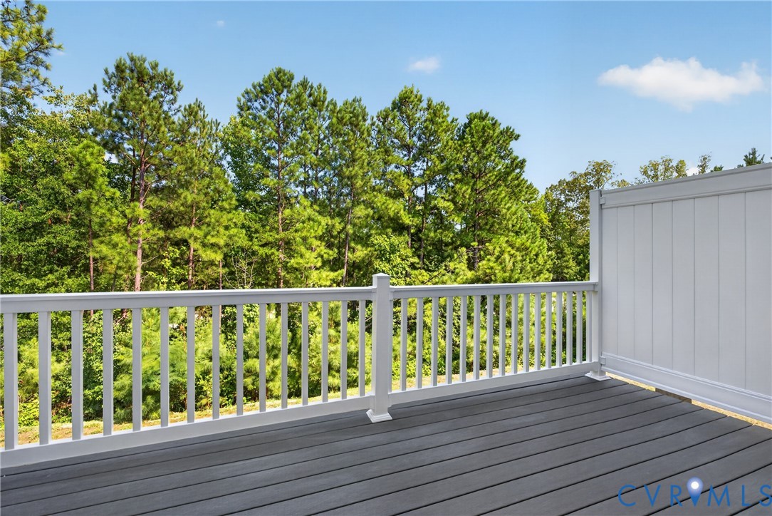 Deck featuring wood-finish flooring, white railing, and a privacy wall
