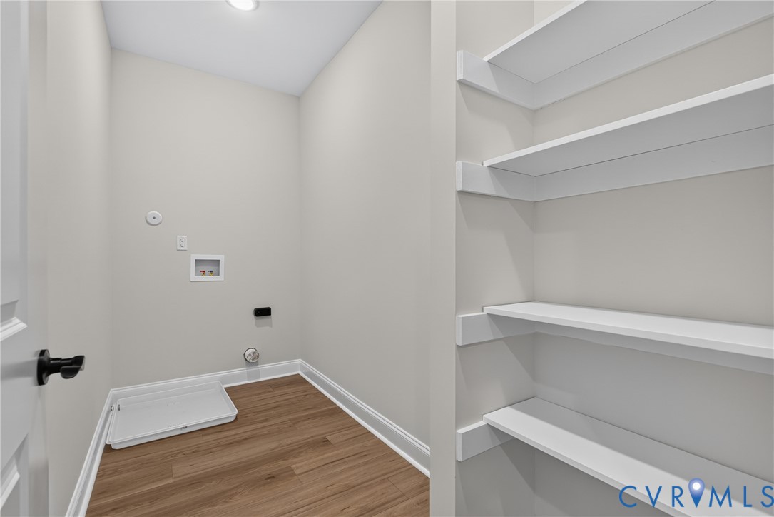 Laundry area featuring wood-finish flooring, recessed lighting, and built-in shelving