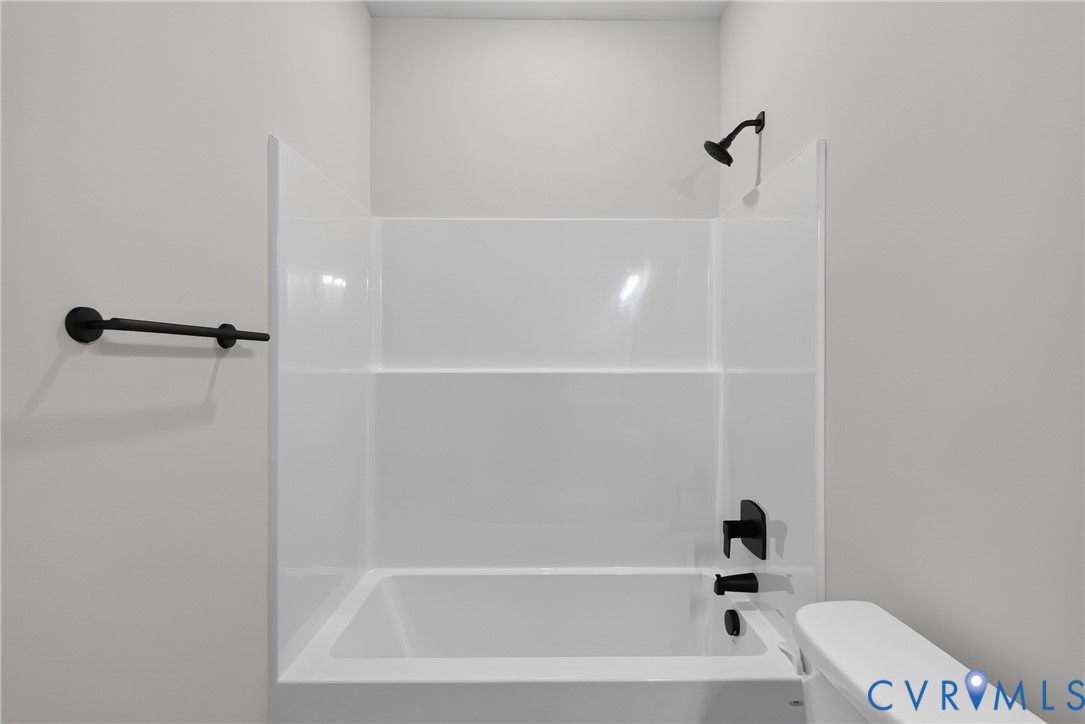 White acrylic tub and shower combination with matte black fixtures