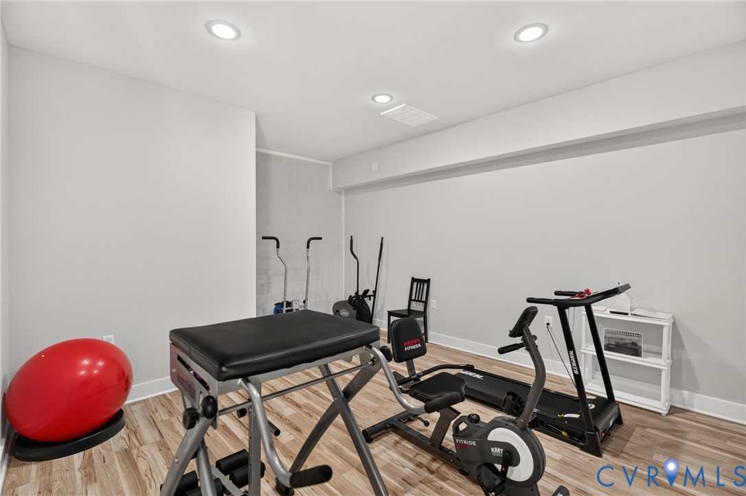 Recessed ceiling lighting, light gray wall paint, and wood-finish flooring