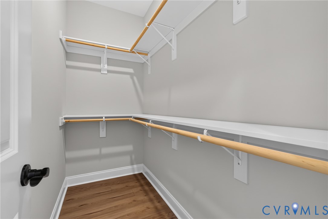 White shelving units, wood-finish flooring, and white trim