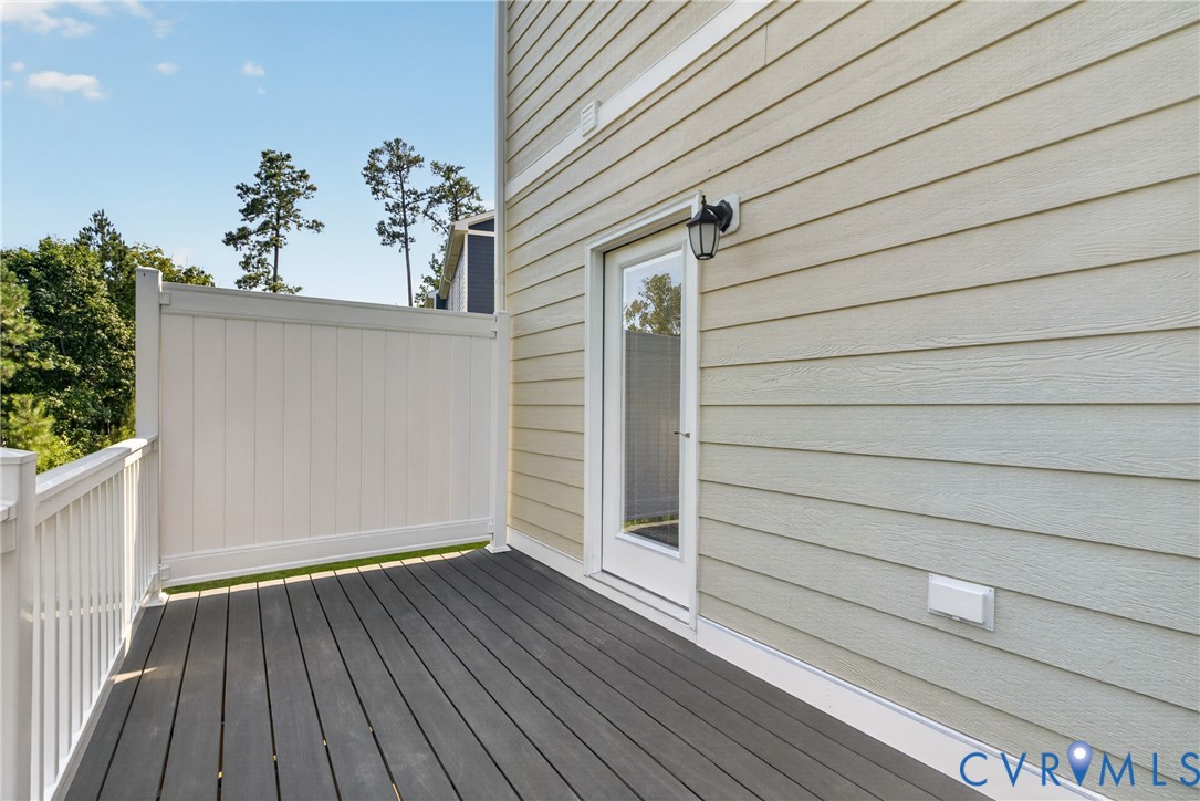 Outdoor deck featuring composite decking, white railing, and a privacy panel