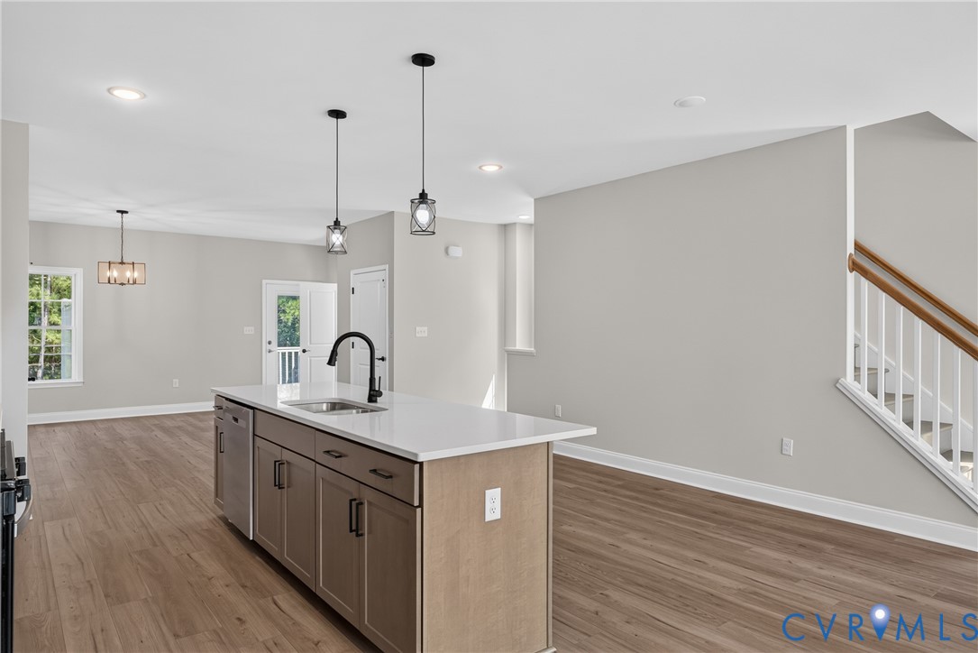 Central kitchen island featuring a sink with a matte black faucet and integrated dishwasher