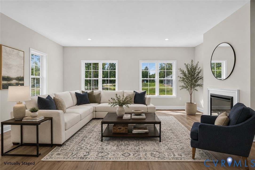 Recessed lighting, wood-finish flooring, multiple windows, and a built-in fireplace