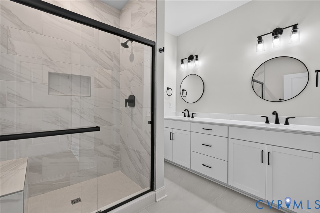 Walk-in shower with a built-in bench, tiled walls, and black-framed glass enclosure