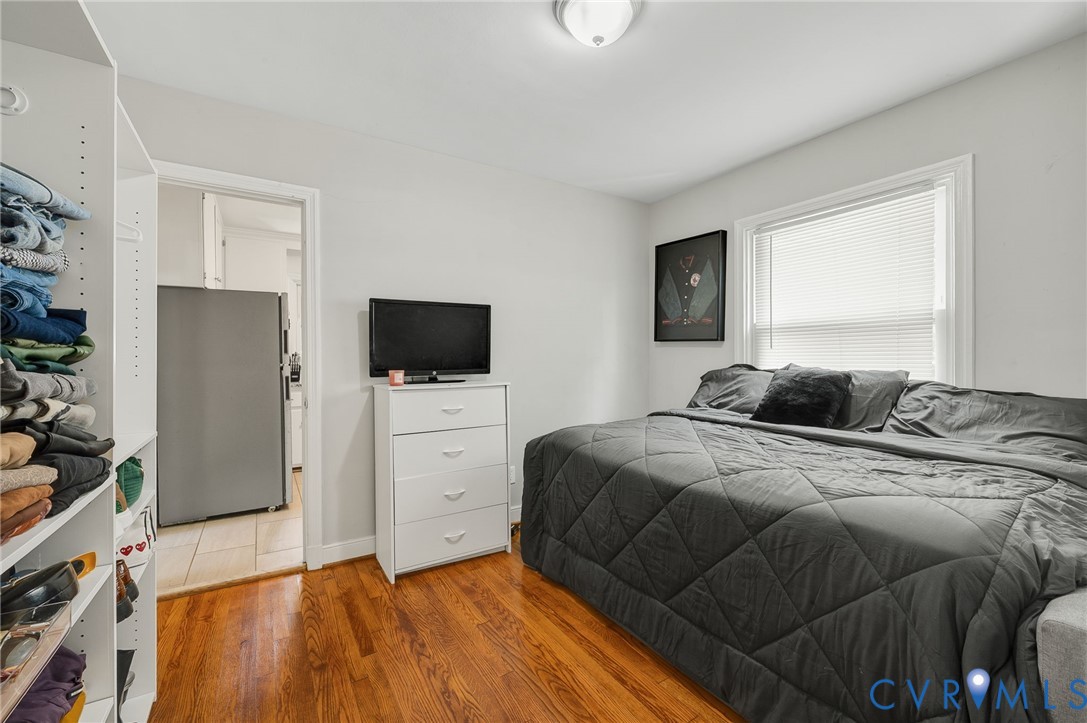 Hardwood flooring, white walls, flush mount ceiling light, built-in shelving, white window blinds