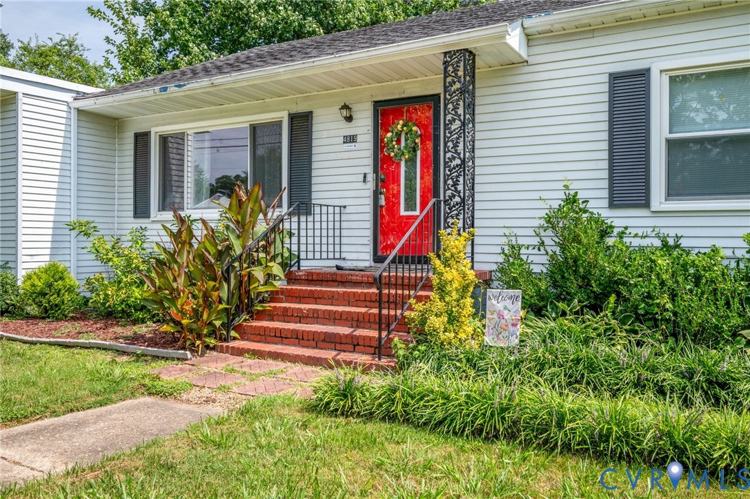 White horizontal siding exterior with a bright red entry door, brick steps, and black decorative porch columns White horizontal siding exterior with a bright red entry door, brick steps, and black decorative porch columns