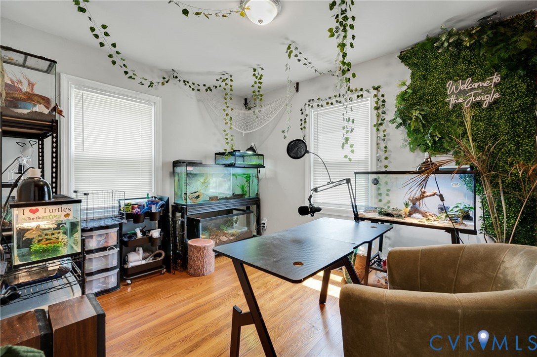 Hardwood-style flooring, white walls, and a ceiling-mounted light fixture