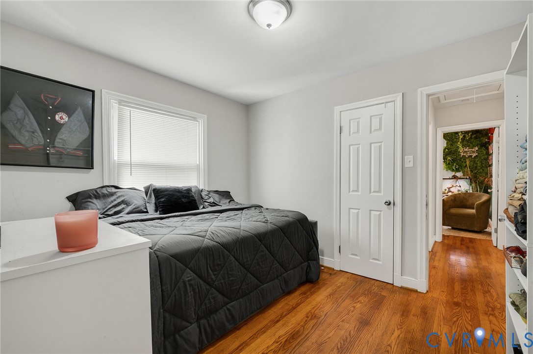Wood-finish flooring, white trim work, and a ceiling-mounted light fixture