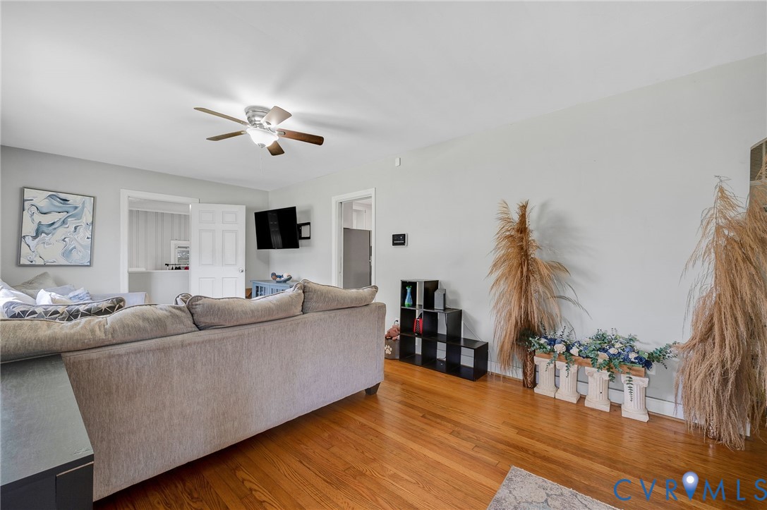 Hardwood-finish flooring, ceiling fan with integrated lighting, and neutral wall tones