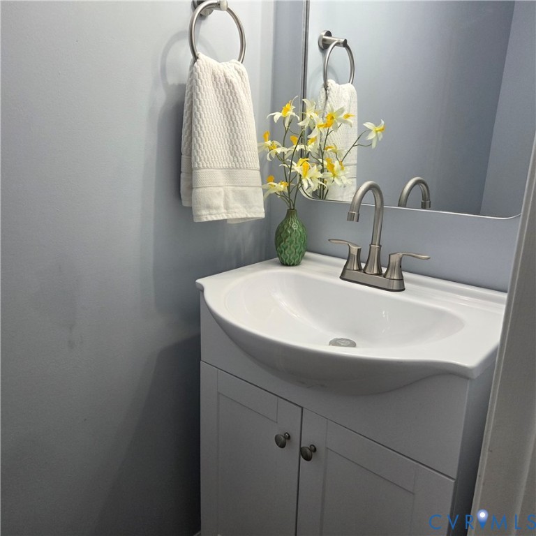 White vanity with cabinet storage, integrated basin, and brushed nickel faucet