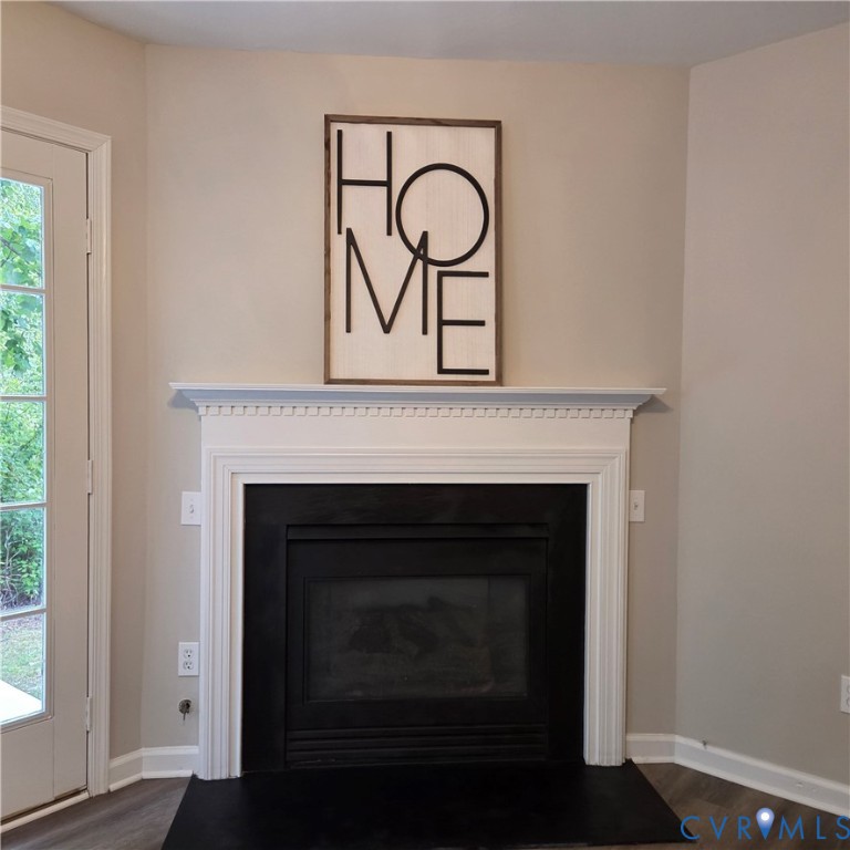 Elegant fireplace with crisp white surround and dentil molding detail, complemented by dark firebox and hearth