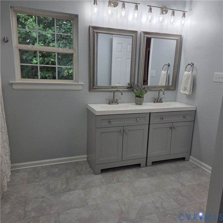 Dual vanity with white countertops, undermount sinks, and chrome faucets
