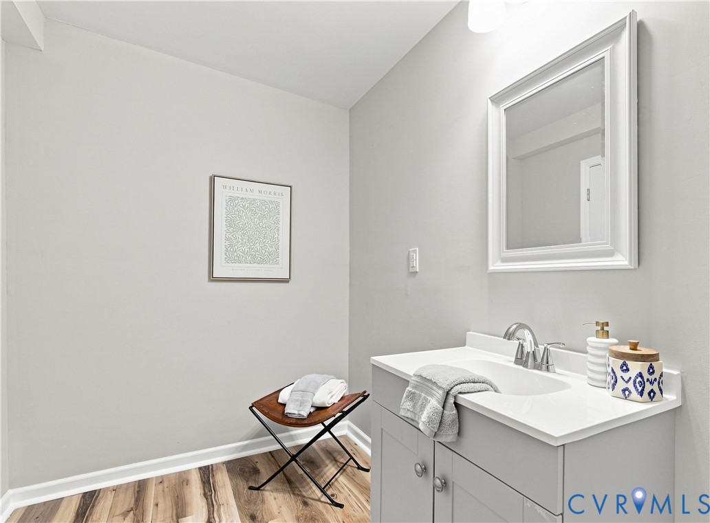 Vanity with integrated sink, chrome faucet, and framed mirror