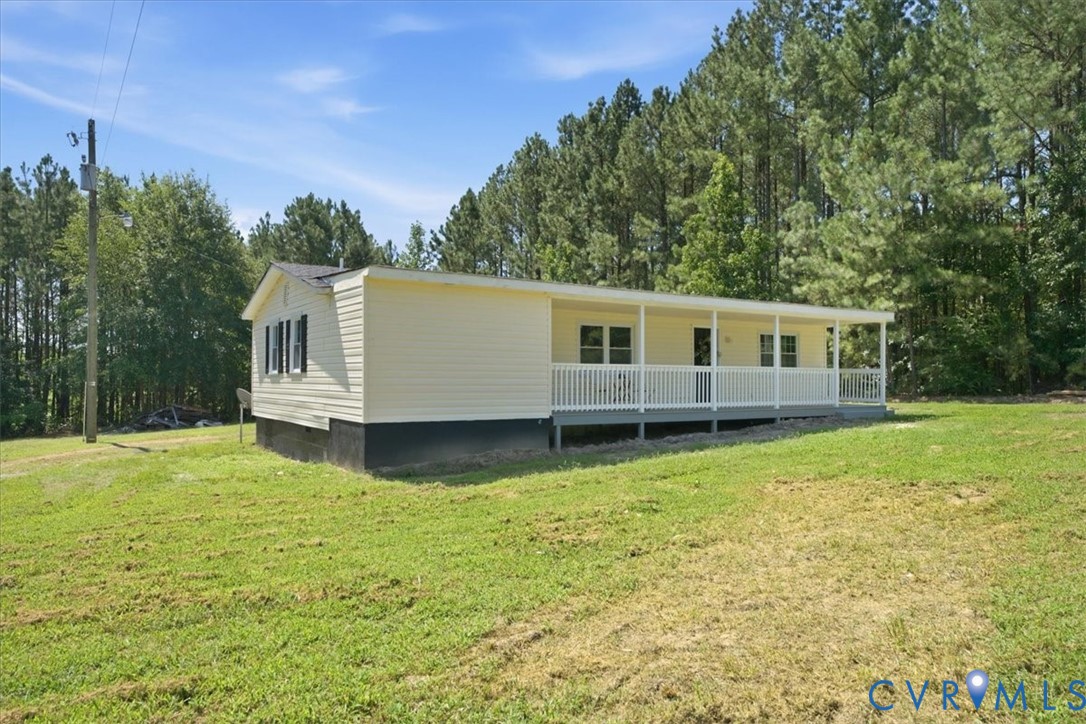 Exterior featuring light-colored siding, a full-length covered porch, white railings, and a dark shingled roof