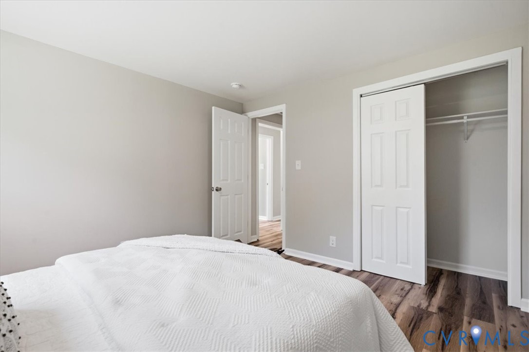 Wood-finish flooring, light gray wall paint, and a built-in closet with sliding panel doors