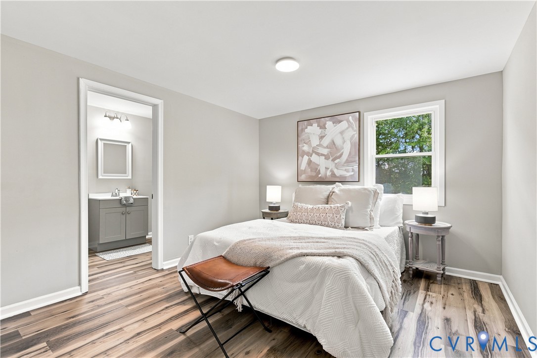 Wood-finish flooring throughout, light gray wall paint, and a single window