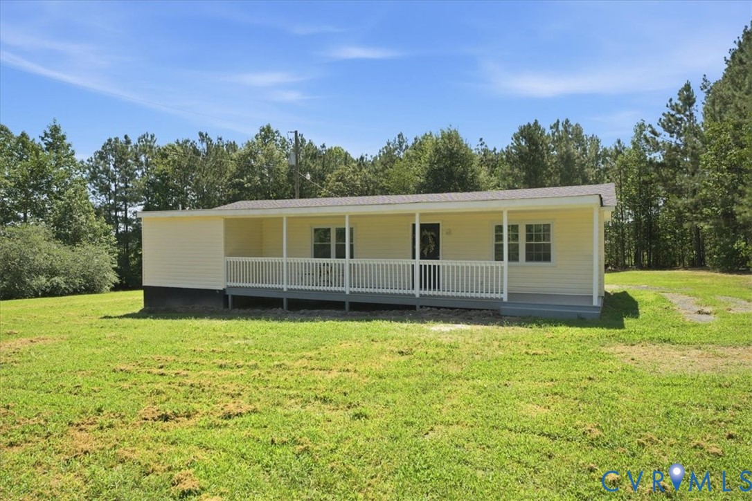 Front porch with white railings, light yellow siding exterior, and a light gray roof