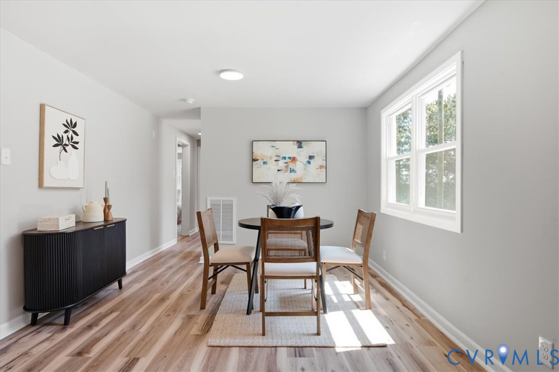 Recessed ceiling lighting, wood-finish flooring, light gray wall finishes, and a double-hung window
