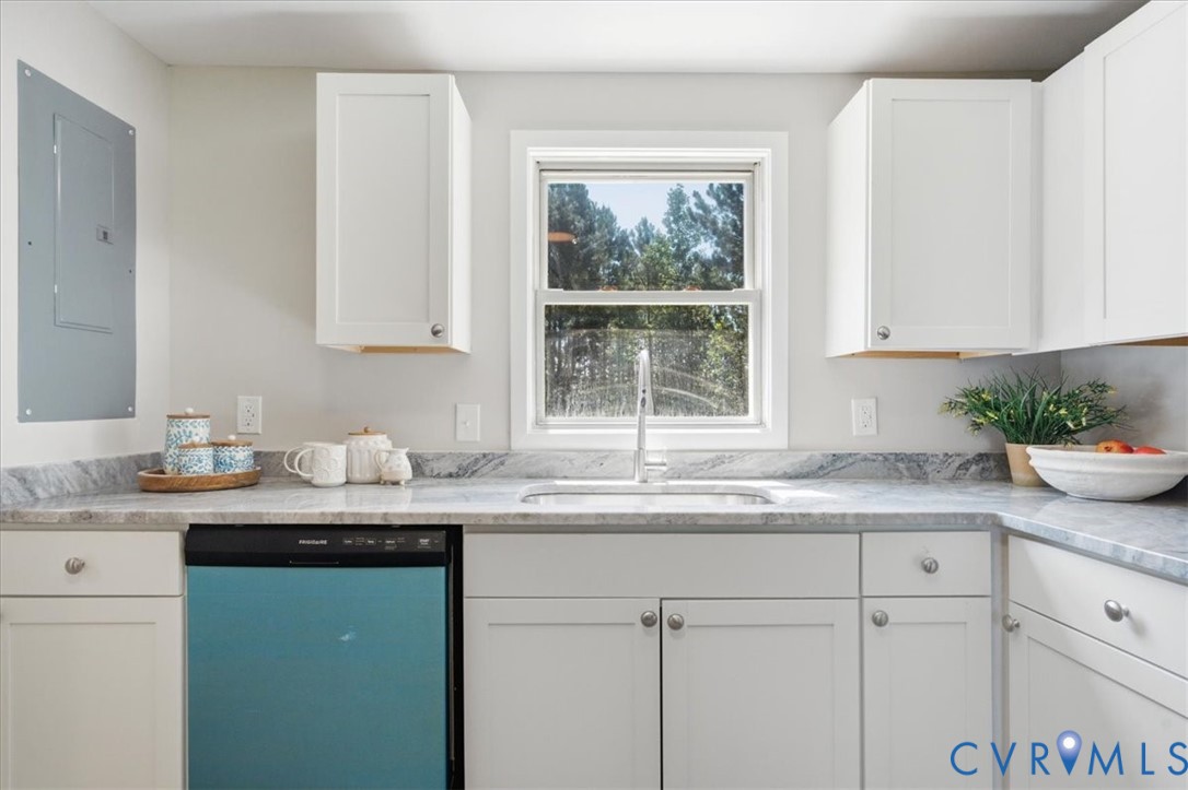 White shaker-style cabinetry with knob hardware, gray patterned countertops, stainless steel sink with a gooseneck faucet, and a built-in dishwasher